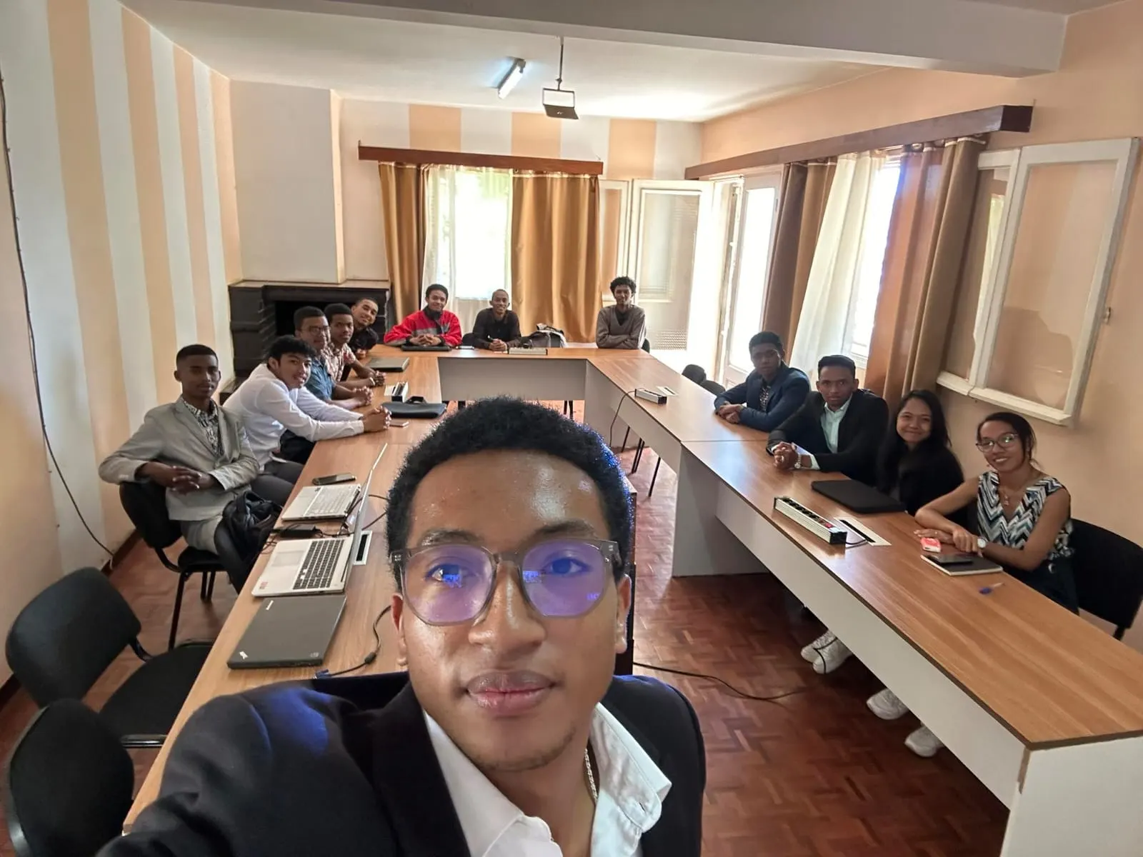 Réunion de travail autour d'une grande table, Herilala RAKOTO au premier plan